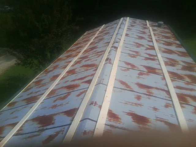 Rusted metal roof panels with new wood purlins before replacement — Storm Damage Roof Repair in Starbuck by Roofing Brothers