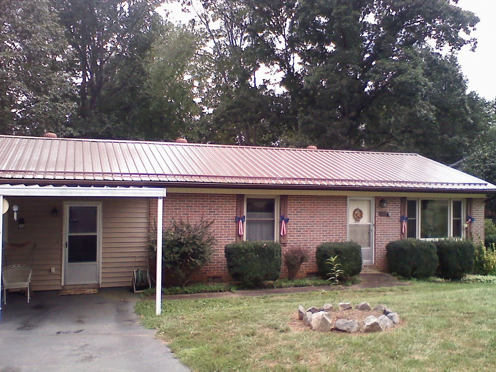 Bronze metal roof and carport on a brick ranch home — Roof Repair work by our crew in Starbuck